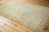 Vintage distressed Oushak carpet corner, highlighting soft beige, faded mint, and subtle geometric detail.