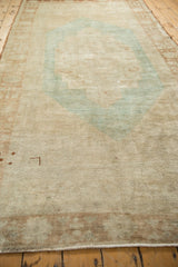Distressed pile texture of a vintage Oushak carpet with time-softened beige and faded blue.