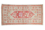 Vintage distressed Oushak runner with a raspberry red medallion and floral motifs in magenta, orange, and ivory.