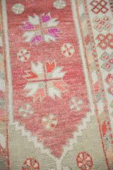 Detail of the even, low-pile wear on a vintage distressed Oushak rug's raspberry red field.