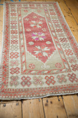 Angled view down a distressed Oushak runner, highlighting its worn texture and starburst medallions.