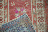 Corner detail of a distressed Oushak rug showing its colorful hand-knotted back and low pile.