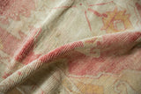 A close view of the low, hand-knotted pile and textural wear on a distressed Oushak rug.
