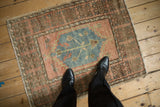 Distressed pile on a vintage Oushak square rug with dusty rose and faded denim blue colors.