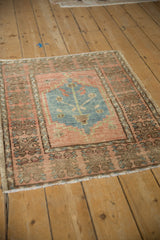 Distressed Oushak rug corner showing stepped cartouche, tree of life, and wide patterned border.