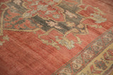 Distressed coral and gray border details on vintage Kurdish carpet, with faded beige motifs.