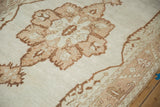 Low-pile texture of the vintage Oushak's starburst medallion in beige and brown.