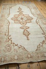 Angled view down the distressed Oushak rug runner, showing its low-pile texture and central medallion.