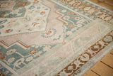 Distressed Taspinar carpet border showing muted brown-gold motifs and neatly secured selvage.