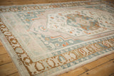 Geometric border and fringe of distressed Taspinar carpet in muted blue, peach, and brown.