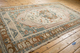 Distressed vintage Taspinar carpet border, showcasing muted teal, rust, and beige geometric patterns.