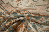 Distressed Taspinar rug pile with geometric patterns in faded blue-green, rust, and beige.