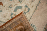 Distressed Taspinar carpet showing worn pile, brown foundation, and secured side cord.