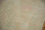 Angled view of a distressed Oushak rug showing mostly even wear to the knot heads.