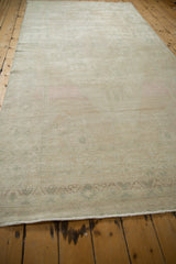 Lengthwise view of the distressed Oushak runner showing its faded ivory field and low-profile wear.