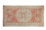 Distressed vintage Oushak runner with a floral medallion in pale raspberry blush and seafoam green.