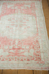 Lengthwise view of a distressed Oushak runner's soft, faded raspberry blush pattern.
