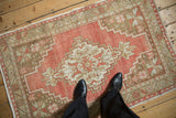 A personal view of the distressed brick red and coffee brown geometric pattern on a vintage Oushak rug.