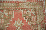 Geometric corner spandrel and starburst motifs on a distressed vintage Oushak rug with low pile.
