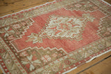 Worn pile on the vintage Oushak rug's stepped corner spandrel and floral border.