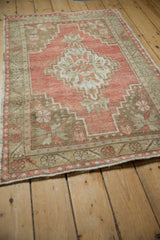 High-angle view of a distressed Oushak rug, showing the stepped medallion and corner spandrels.