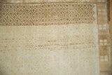 Corner view of a Kars carpet's geometric border and the heavily abraded, low-pile ivory field.