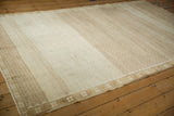 Color variations from abrashes across the geometric lattice field of a vintage distressed Kars rug.