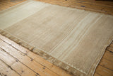 Angled view of a vintage Kars carpet highlighting its geometric lattice and sand-toned abrash.