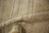 Textured close-up of a vintage distressed rug with a short pile and geometric lattice design.