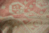 A soft fold showing the evenly worn, hand-knotted pile of a distressed Oushak rug.