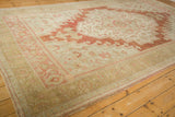 Distressed texture of a vintage Oushak rug, with faded beige and warm terracotta motifs.