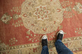 Distressed Anatolian runner with faded red field, roundel medallion, and scrolled vines.
