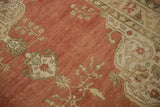 Distressed Anatolian rug's faded red pile with ivory arabesque vines and turquoise accents.