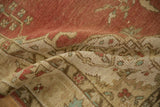 Textured folds reveal faded red, beige, and turquoise patterns of the distressed Anatolian rug.