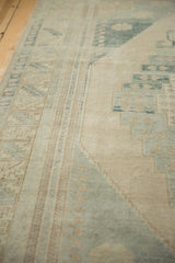 Geometric patterns in soft beige and muted blue with distressed low pile on a vintage Oushak carpet.
