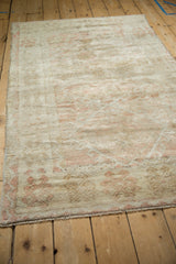 Low-angle view of the distressed vintage rug's textured pile and knot heads.