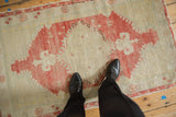 A vintage Turkish Oushak rug showing the scale of its raspberry red geometric medallion.
