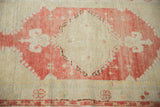 Close-up of the distressed hand-knotted pile on the raspberry red and ivory geometric medallion.