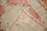 Reverse view of a distressed Oushak rug showing its hand-knotted foundation and secured side.