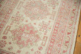 Angled view of a distressed rug's starburst medallion and serrate leaf border.