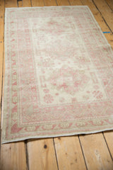 Angled view of the distressed Anatolian rug, highlighting the full length and faded raspberry design.