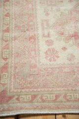 Close view of the mostly even wear on the hand-knotted pile in faded raspberry and ivory.