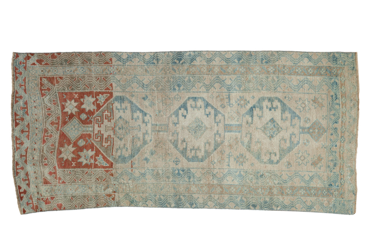 Distressed Anatolian rug with three blue geometric medallions and a striking terracotta red dye lot change.