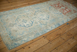Angled view of a distressed Anatolian rug showing the strong copper-red dye lot variation.