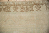 A vintage Oushak corner showing the soft, evenly worn pile and coffee brown geometric border.