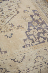 Low pile texture and muted blue geometric patterns on a distressed Taspinar carpet.