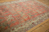 Distressed Oushak rug field with blush botehs, charcoal, and a germinating blossom border.