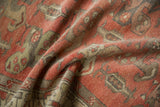 Muted blush, charcoal, and beige tones on a distressed Oushak rug's worn pile.