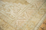 Corner detail of distressed Oushak carpet with worn beige and soft blue floral border.