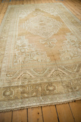 Close-up of the Oushak rug's distressed fringe and faded floral border.